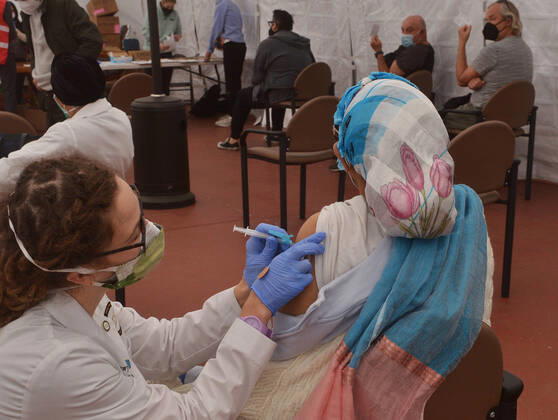 A local resident receives a COVID-19 vaccination shot at the Kedren Community Health Center in South Los Angeles on Tuesday, February 16, 2021. To boost vaccination among people of color, L.A. county plans more sites, better messaging and access to transit. Black, Latino and Native American seniors are being vaccinated at lower rates than other groups.  LAP2021021616 JIMxRUYMEN