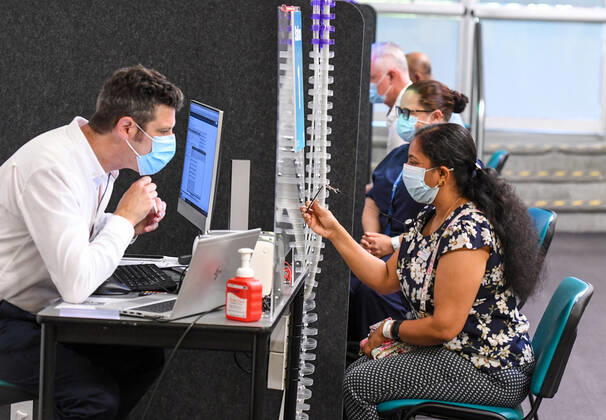 NSW COVID19 VACCINE ROLLOUT, Gayathry Vellangalloor Srinivasan, the first person in NSW to received the Pfizer coronavirus vaccine, registers with medial workers at the Royal Prince Alfred Hospital Vaccination Hub in Sydney, Monday, February 22, 2021. Australia will begin its roll out of the Pfizer coronavirus vaccine on Monday, the country s most complicated logistical exercise to date. ( NO ARCHIVING, EDITORIAL USE ONLY, NO USE IN BOOKS WITHOUT CONSENT SYDNEY NSW AUSTRALIA  Copyright: xPETERxRAEx 20210222001522241420