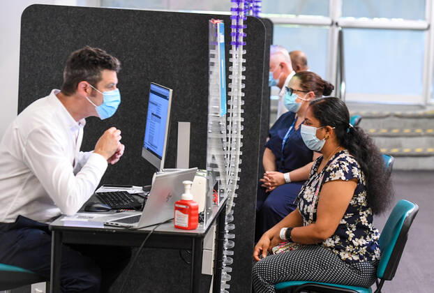 NSW COVID19 VACCINE ROLLOUT, Gayathry Vellangalloor Srinivasan, the first person in NSW to received the Pfizer coronavirus vaccine, registers with medial workers at the Royal Prince Alfred Hospital Vaccination Hub in Sydney, Monday, February 22, 2021. Australia will begin its roll out of the Pfizer coronavirus vaccine on Monday, the country s most complicated logistical exercise to date. ( NO ARCHIVING, EDITORIAL USE ONLY, NO USE IN BOOKS WITHOUT CONSENT SYDNEY NSW AUSTRALIA  Copyright: xPETERxRAEx 20210222001522241450
