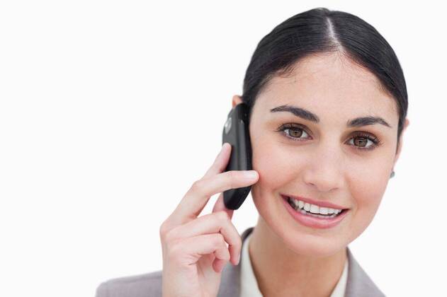 Close up of smiling businesswoman talking on cellphone Close up of smiling businesswoman talking on cellphone against a white background, model released, Cape Town, South Africa, 08.11.2011, 105737.jpg, beautiful, businesswoman, career, confident, elegant, employee, happy, pretty, smile, standing, full suit, worker, smiling, well dressed, brown hair, tied hair, brunette, mobile, phone, talking, calling, listening 20s, Young Adult, Woman, Female, Caucasian, 25-29 Years, Young Women, Caucasian Appearance Close-up,Copy space,Front view,Head and shoulders,Looking at camera,Studio shot,White background