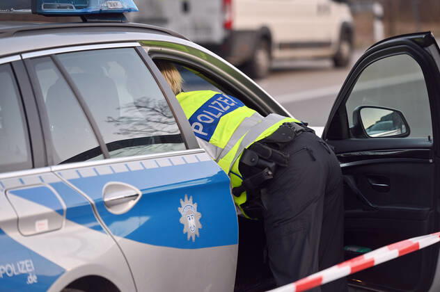 Border controls at the Austrian-German border ,border crossing Kiefersfelden border police officers control motorists entering Bavaria from Tyrol Austria Germany police woman in yellow high-visibility vest leans into a police car,