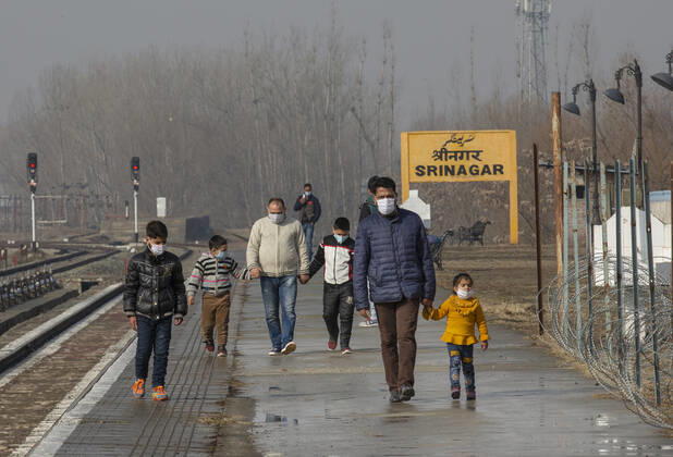 (210223) -- SRINAGAR, Feb. 23, 2021 -- Passengers wearing face masks walk on a railway platform in Srinagar city, the summer capital of Indian-controlled Kashmir, Feb. 23, 2021. Train service was resumed partially in Indian-controlled Kashmir after a gap of 11 months, officials said Tuesday. The service was suspended on March 19 last year owing to the outbreak of the COVID-19 pandemic. ) KASHMIR-TRAIN SERVICE-RESUMPTION JavedxDar