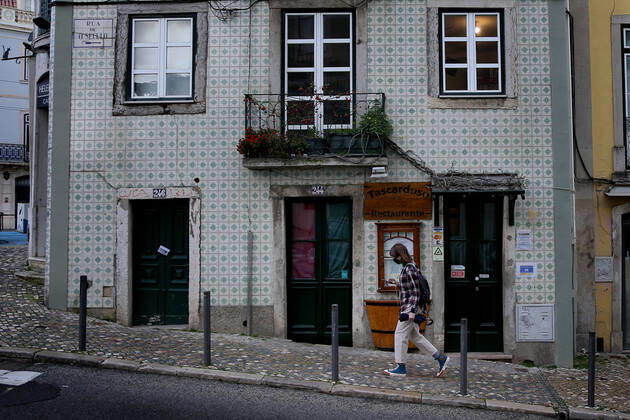 February 25, 2021, Lisbon, Portugal: A woman wearing a face mask walks by a closed restaurant in Lisbon, Portugal on February 25, 2021. Portugal s parliament approved on Thursday the renewal of the state of emergency in the country through March 16, allowing the government to keep all lockdown and anti-COVID-19 measures in place. Lisbon Portugal - ZUMAf123 20210225_zap_f123_002 Copyright: xPedroxFiuzax