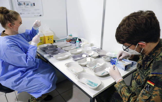Impfzentrum Schoenefeld Schoenefeld, DEU, 26 02 2021 Syringes are filled with Covid19 Biontech Pfizer vaccine Comirnaty by soldiers of the German Armed Forces, in the vaccination centre at terminal 5 of BER airport Schoenefeld Brandenburg Germany