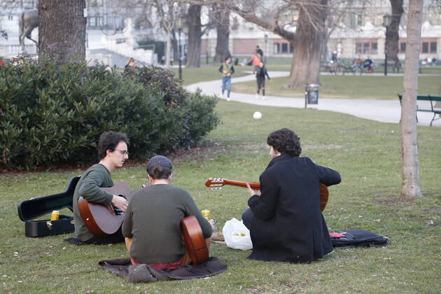 Coronas Stuation in Vienna Vienna, Innere Stadt, 25 02 2021 Corona Pandemic, Corona, Corona Virus, CoV 2, Covid 19, Sars, Virus, Virus Infection, Pandemic, Corona Crisis, Viral Disease, Coronavirus, SARS CoV 2 people sitting in the lawn, Burggarten, spring guitarist, playing guitar, making music outdoors, making music Vienna Austria AVN101002455133