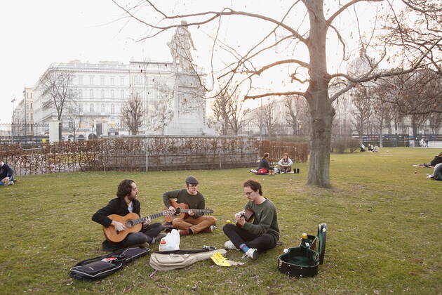 Coronas Stuation in Vienna Vienna, Innere Stadt, 25 02 2021 Corona Pandemic, Corona, Corona Virus, CoV 2, Covid 19, Sars, Virus, Virus Infection, Pandemic, Corona Crisis, Viral Disease, Coronavirus, SARS CoV 2 people sitting in the lawn, Burggarten, spring guitarist, playing guitar, making music outdoors, making music Vienna Austria AVN101002455135