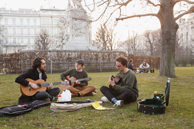 Coronas Stuation in Vienna Vienna, Innere Stadt, 25 02 2021 Corona Pandemic, Corona, Corona Virus, CoV 2, Covid 19, Sars, Virus, Virus Infection, Pandemic, Corona Crisis, Viral Disease, Coronavirus, SARS CoV 2 people sitting in the lawn, Burggarten, spring guitarist, playing guitar, making music outdoors, making music Vienna Austria AVN101002455136