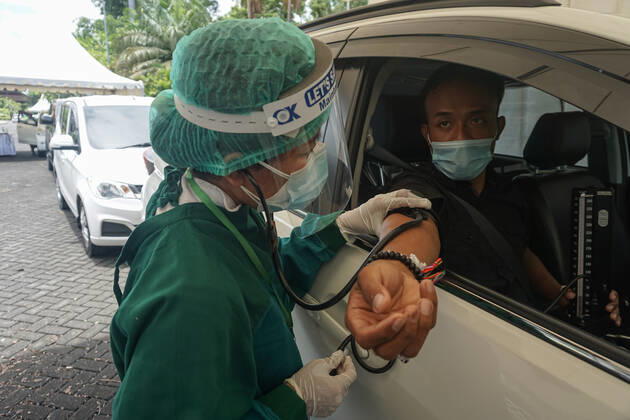 February 28, 2021, Badung, Bali, Indonesia: A healthworker serving health-screening before the drive-thru vaccination process. Bali to held the second stage of Covid-19 mass vaccination towards tourism workers and online-taxi drivers at Bali Nusa Dua Convention Center (BNDCC), in order to accelerate tourism industry recovery. About 5000 doses of vaccines are targeted to be completed within 1 week. Badung Indonesia - ZUMAb245 20210228_zip_b245_001 Copyright: xDickyxBisinglasix