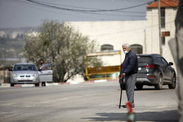 February 28, 2021, Jenin, West Bank, Palestinian Territory: A man walks on an empty street, amid the coronavirus lockdown in the town of Zababdeh, south of Jenin, in the West Bank on February 28, 2021. Prime Minister Mohammad Shtayyeh announced a new set of restrictions in response to a recent surge in coronavirus infections, including of British and South African mutants, in Palestine.A lockdown of all public and private schools for all classes, except for high school students for a period of 12 days, including kindergartens..A lockdown of all universities, educational and vocational institutes and shifting to distance e-learning programs. A maximum of 50 percent of administrative staff are allowed access to universities..Movement between - ZUMAap3_ 20210228_zaf_ap3_044 Copyright: xOdayxDaibesx