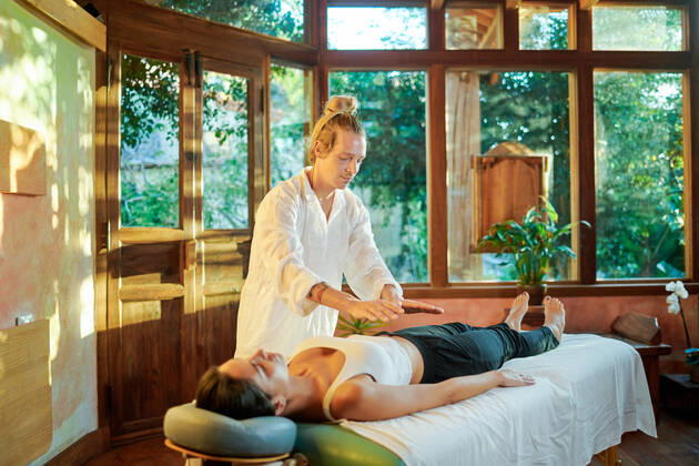 IMAGO Creative, Lifestyle, Esoterik gef?hrlicher Glaube Healer practicing palm healing technique for female client lying on couch during spiritual practice for filling with harmony and energy, Model released, Property released Copyright: xGabrielxTrujillox MR