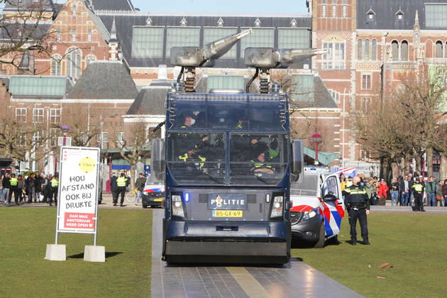 Dutch anti-riot police officers water cannon vehicle team take position near anti-lockdown supporters during illegal demonstration against the coronavirus measures at the Museumplein on February 28, 2021 in Amsterdam,Netherlands. Amsterdam Mayor Femke Halsema classified the Museumplein as security risk area , giving police officers the right to check and search anybody in that area to prevent illegal demonstration and vandalism. Amsterdam Netherlands Copyright: xPauloxAmorimx amp20210228_005
