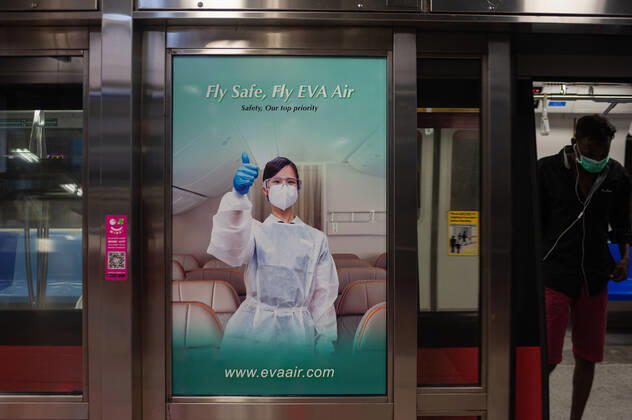 28 02 2021, Singapore, Republic of Singapore, Asia A billboard on the platform of an MRT subway station advertises safe air travel with Taiwanese airline EVA AIr amid the ongoing Corona crisis Covid 19
