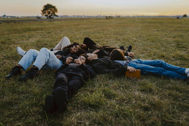 Young male and female friends lying on grass in park Germany, Berlin, model released Copyright: xMaskotx , MA84315
