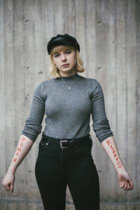 Portrait of female protestor showing equal rights written on hand against wall Sweden, Stockholm, model released Copyright: xMaskotx , MA84419