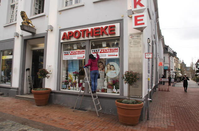 The Moers city centre in Corona times View of the Moers pedestrian zone in Corona times The Moers Löwen pharmacy offers free Corona testing The employees put up signposts and advertising posters for the testing With the inscription Test Centre Free testing according to the regulation of the federal government Moers Germany North Rhine Westphalia