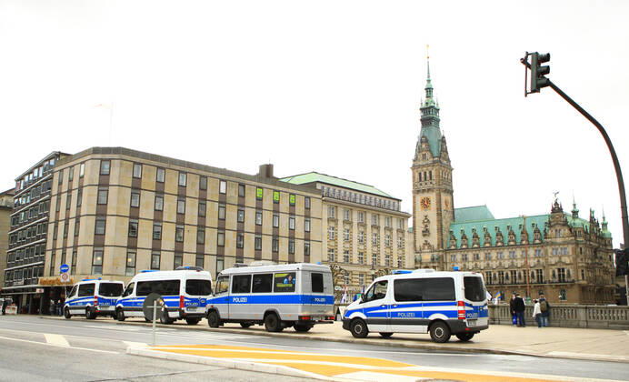 Police patrol cars are parked at the Reesendamm Bridge on Hamburgs Jungfernstieg In the background, Hamburgs City Hall Police forces prepare for a demonstration by critics of the federal governments Corona policy, which will take place on the Rathausplatz Downtown Hamburg