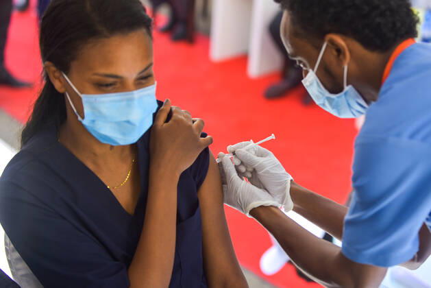 (210313) -- ADDIS ABABA, March 13, 2021 -- A woman receives the COVID-19 vaccine in Addis Ababa, Ethiopia, on March 13, 2021. Ethiopian State Minister of Health Dereje Duguma disclosed on Saturday that the east African country plans to give COVID-19 vaccine jabs to 20 percent of its population by March 2022. Duguma disclosed the plan during a ceremony in Addis Ababa to officially start COVID-19 vaccine jabs in the country. ) ETHIOPIA-ADDIS ABABA-COVID-19 VACCINATION-START MichaelxTewelde 