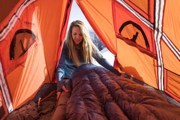Young female setting up sleeping bag in tent while winter camping Aspen, CO, United States CR_BRHU210312-245189-01 ,model released, Symbolfoto