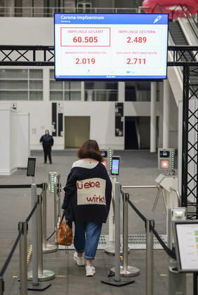 DEUTSCHLAND, Hamburg, Corona Pandemie, Impfzentrum der KVH und Sozialbehörde Hamburg in den Messehallen, groesstes Impfzentrum Deutschlands fuer bis zu 7000 Menschen taeglich, Impfung von alten Menschen und jungen Menschen in systemrelevanten Berufen, Mitarbeiter Eingang mit digitaler Fiebermessung Hamburg Germany
