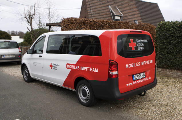 DRK Einsatzfahrzeug Mobiles Impfen Einsatzfahrzeug des DRK Wesel mit der Aufschrift Mobiles Impfteam. Das Fahrzeug wird genutzt zum Transport der Impfdosen zu den Impfzentren oder ambulanten Impforten. Das Fahrzeug steht vor einem Privathaus. Moers Deutschland Nordrhein-Westfalen NRW