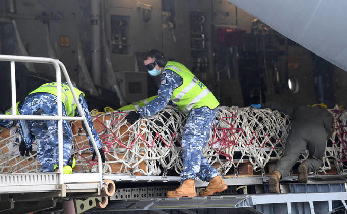 AUSMAT VACCINE PNG COVID19 RESPONSE, Royal Australian Air Force personal are seen loading COVID-19 vaccines and humanitarian supplies onto a C-17A Globemaster at RAAF Base Amberley, west of Brisbane, Tuesday, March 23, 2021. Australia are sending 8,000 doses of its COVID-19 vaccine supply to Papua New Guinea who have more than 1,400 active cases of COVID-19 and the Australian government are asking AstraZeneca and European authorities to divert another 1 million doses to Papua New Guinea. ( NO ARCHIVING, EDITORIAL USE ONLY, NO USE IN BOOKS WITHOUT CONSENT BRISBANE QLD AUSTRALIA  Copyright: xDARRENxENGLANDx 20210323001529485314