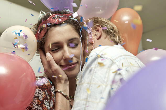IMAGO Creative: 2022 Farbe des Jahres: Very Peri, Veilchenblau Young man and woman kissing at a party model released Symbolfoto AJOF01134