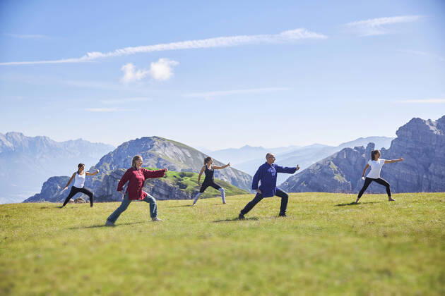 Man and women practicing yoga on meadow against sky model released Symbolfoto CVF01667