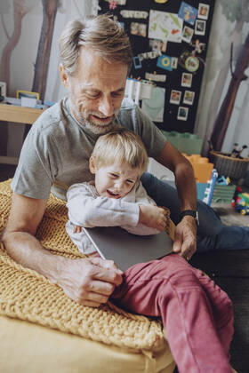 Father struggling while taking digital tablet from displeased son model released Symbolfoto property released MFF07172
