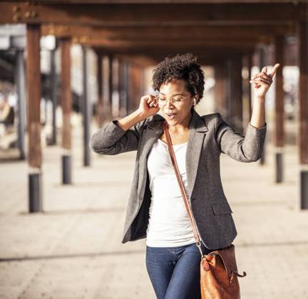 Young woman dancing while listening music on footpath model released Symbolfoto UUF23069