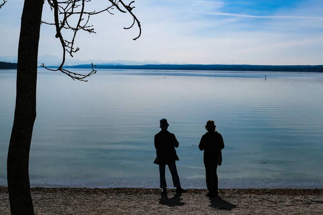 Spring weather at the Ammersee 25 03 2021 Excursionist in spring weather at the shore of the Ammersee near Stegen Inning at the Ammersee Upper Bavaria with view towards the Alps Inning Bavaria Germany