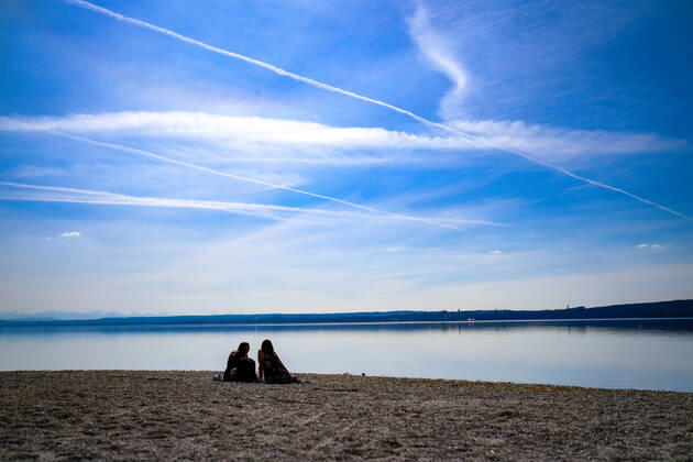 Spring weather at the Ammersee 25 03 2021 Excursionist in spring weather at the shore of the Ammersee near Stegen Inning at the Ammersee Upper Bavaria with view towards the Alps Inning Bavaria Germany