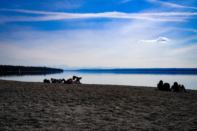 Spring weather at the Ammersee 25 03 2021 Excursionist in spring weather at the shore of the Ammersee near Stegen Inning at the Ammersee Upper Bavaria with view towards the Alps Inning Bavaria Germany