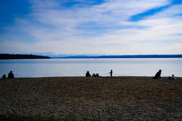 Spring weather at the Ammersee 25 03 2021 Excursionist in spring weather at the shore of the Ammersee near Stegen Inning at the Ammersee Upper Bavaria with view towards the Alps Inning Bavaria Germany