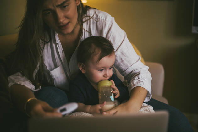 Mother checking temperature of baby girl while taking advice through online consultation at home during pandemic Sweden, Stockholm, model released, property released Copyright: xMaskotx , MA85671