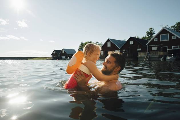 IMAGO Creative, Jahreszeit Sommer, Sommerferien IMAGO Creative: Vaterschaft IMAGO Creative: Dichotomien, Reflexionen Side view of cheerful daughter with father in lake during vacations Sweden, Tierp, model released Copyright: xMaskotx , MA85508