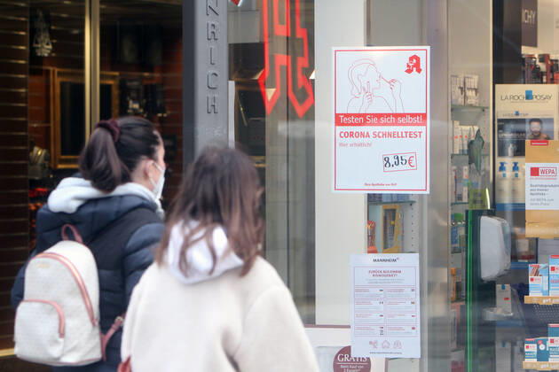 Sticker with inscription Testen sie sich selbst, Corona Schnelltest hier erhältlich sticks on the shop window of a pharmacy in the pedestrian zone and shopping street Planken in the city centre of Mannheim, Baden Württemberg, Germany