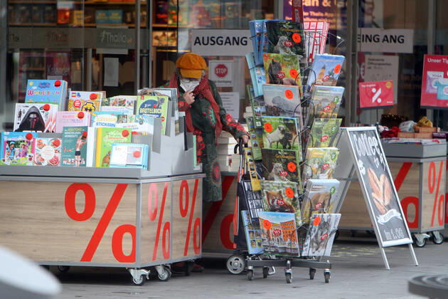 A customer browses in a rack of an open bookstore in downtown Mannheim, Baden Württemberg, Germany