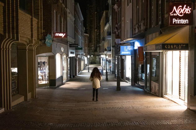 Like an abandoned city. Aachen on Easter vigil between 10 p.m. and 11 p.m. Glance into the deserted Krämerstrasse. A single woman walks through the pedestrian zone. In Aachen on April 3, 2021. GERMANY - AACHEN - EASTER Easter 2021 Covid Pandemic