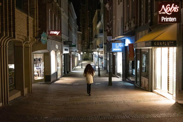 Like an abandoned city. Aachen on Easter vigil between 10 p.m. and 11 p.m. Glance into the deserted Krämerstrasse. A single woman walks through the pedestrian zone. In Aachen on April 3, 2021. GERMANY - AACHEN - EASTER Easter 2021 Covid Pandemic