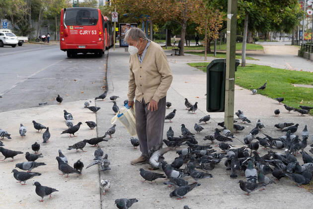 April 4, 2021, Santiago, Metropolitana, Chile: A man with a mask feeds pigeons, amid the total quarantine decreed last week for the Metropolitan Region. Santiago Chile - ZUMAb332 20210404_zip_b332_036 Copyright: xMatiasxBasualdox