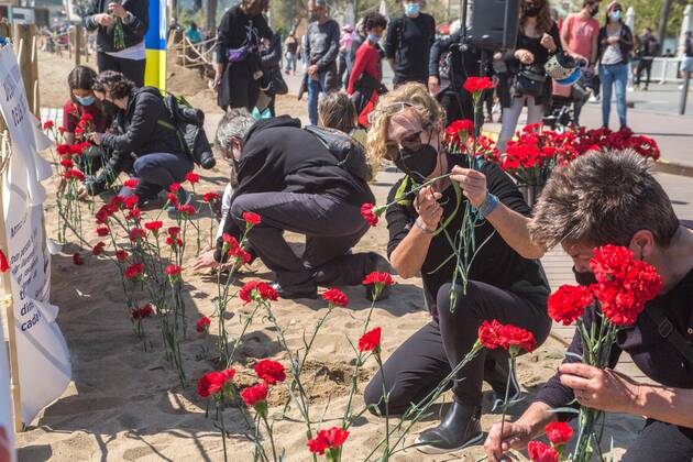 April 18, 2021, Barcelona, Catalonia, Spain: People are seen putting carnation seedling on beach sand.Stop Mare Mortum, a platform that aims to promote a change in European immigration and immigration policies in order to ensure that human rights are guaranteed and respected, has carried out, on Barceloneta beach in Barcelona, an visual action to denounce the constant deaths in the Mediterranean and the Atlantic. Some 150 people have carried out a carnation planting on behalf of the more than 1200 people who died during 2020 on the route to reach the Canary Islands. Barcelona Spain - ZUMAd159 20210418_zia_d159_001 Copyright: xThiagoxPrudenciox