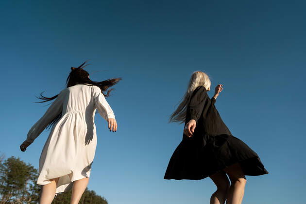 two beautiful twin girls doing style lying in a field at sunset CR_NAOS210419-715200-01 ,model released, Symbolfoto