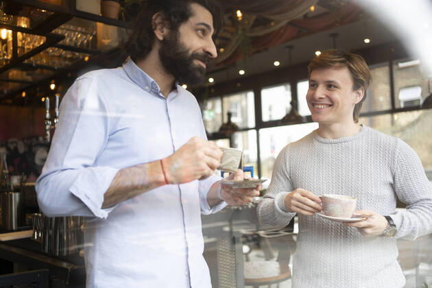 Male coworkers having coffee during break time at office model released Symbolfoto property released FBAF01689
