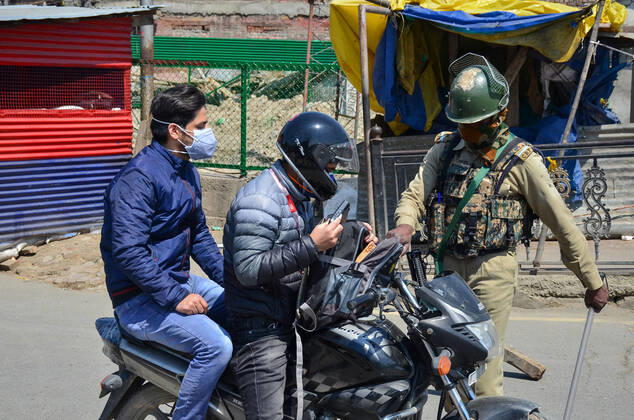 April 30, 2021, Srinagar, India: A paramilitary trooper frisks a motorcyclist during a lockdown imposed by the authorities following the surge in coronavirus cases in Srinagar..With the increasing number of COVID-19 cases in Jammu and Kashmir, the government has imposed an 84-hour lockdown. The situation has worsened during the last one week with both the numbers of new cases and deaths registering a steep rise. Meanwhile, India records nearly 386,555 new COVID-19 cases and 3,501 deaths in the last 24 hours. Srinagar India - ZUMAs197 20210430_zaa_s197_016 Copyright: xSaqibxMajeedx