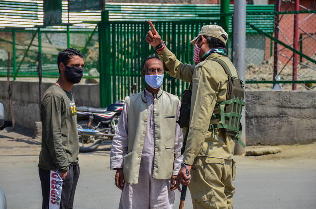 April 30, 2021, Srinagar, India: A paramilitary trooper stops commuters wearing face masks during a lockdown imposed by the authorities following the surge in coronavirus cases in Srinagar..With the increasing number of COVID-19 cases in Jammu and Kashmir, the government has imposed an 84-hour lockdown. The situation has worsened during the last one week with both the numbers of new cases and deaths registering a steep rise. Meanwhile, India records nearly 386,555 new COVID-19 cases and 3,501 deaths in the last 24 hours. Srinagar India - ZUMAs197 20210430_zaa_s197_018 Copyright: xSaqibxMajeedx