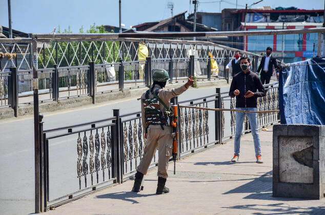 April 30, 2021, Srinagar, India: A paramilitary trooper stops a commuter during a lockdown imposed by the authorities following the surge in coronavirus cases in Srinagar..With the increasing number of COVID-19 cases in Jammu and Kashmir, the government has imposed an 84-hour lockdown. The situation has worsened during the last one week with both the numbers of new cases and deaths registering a steep rise. Meanwhile, India records nearly 386,555 new COVID-19 cases and 3,501 deaths in the last 24 hours. Srinagar India - ZUMAs197 20210430_zaa_s197_019 Copyright: xSaqibxMajeedx