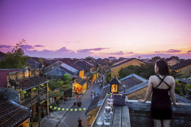 IMAGO Creative: Urbane Kultur - Sommer auf den Dächern Tourists walk down the colonial streets in historic old town Hoi An. Chinese lanterns illuminate the walkways as tourists watch the sunset from a rooftop restaurant; Hoi An, Quang Nam, Vietnam Copyright: MicahxWright 33338936