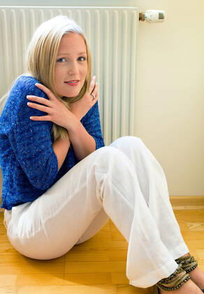 A young woman sits in front of a radiator in winter Room temperature is too low McPBBO McPBBO