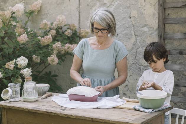 Grandmother preparing bread by grandson playing with dough at back yard model released Symbolfoto property released ALBF01608