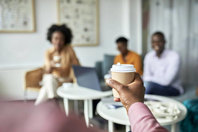 Businessman holding disposable coffee cup at coworking office model released Symbolfoto property released ZEDF04050